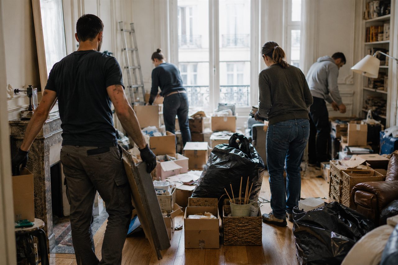 Équipe familiale Sétouch débarras en intervention, vue de dos, dans un logement à débarrasser
